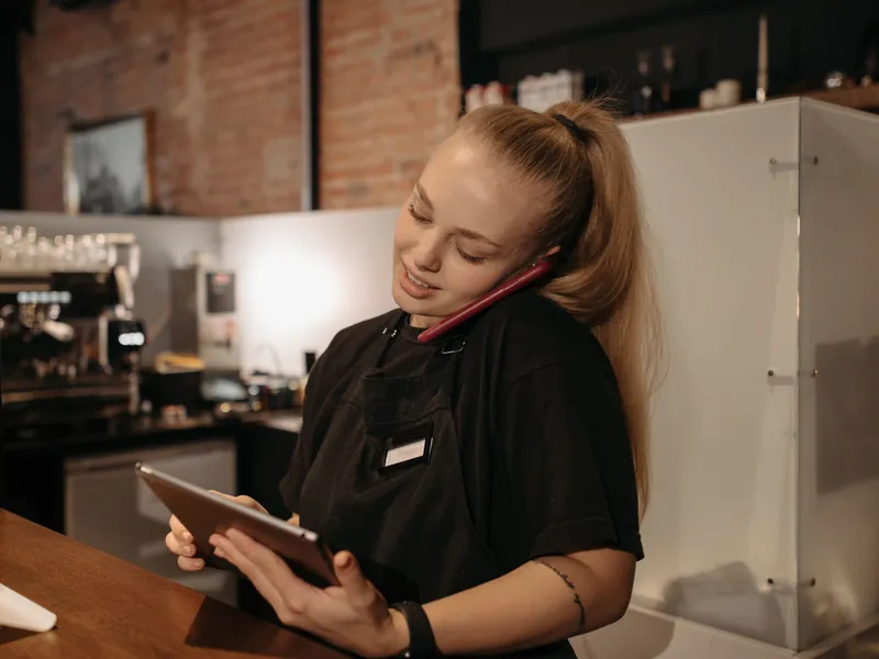 Restaurant staff member taking a phone order at the counter